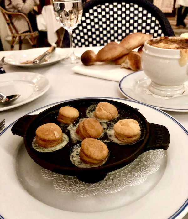 A black cast iron dish filled with snails topped with puff pastry at Thomas Keller's Bouchon Las Vegas