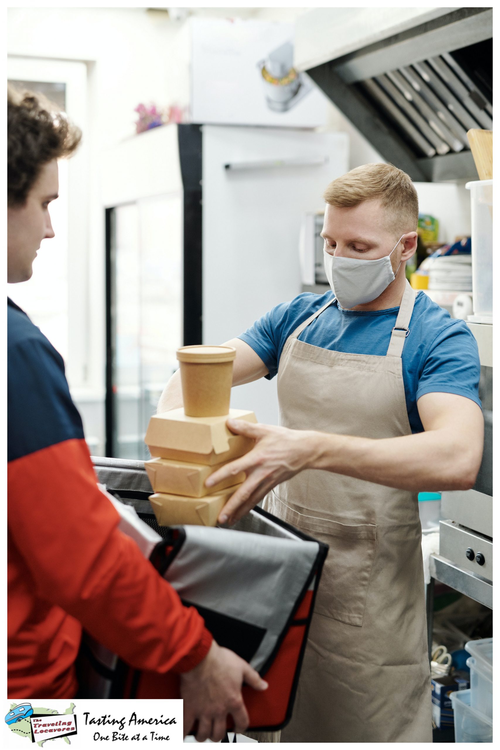 A man in a Covid mask placing boxed food in a thermal container being held by another man is one of the 5 changes in restaurants caused by the pandemic that are here to stay.