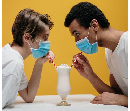 A man and a woman sharing a milkshake with 2 straw while wearing masks from 5 changes in restaurants caused by the pandemic that are here to stay