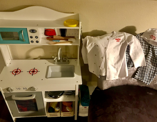 Toy kitchen next to a child's chef coat, hat and pants seen during A Day with Friends in Windsor California