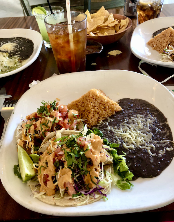 A large white plate topped with tuna tacos, a pyramid of red rice and a pool of black beans topped with cheese enjoyed on A Day with Friends in Windsor California