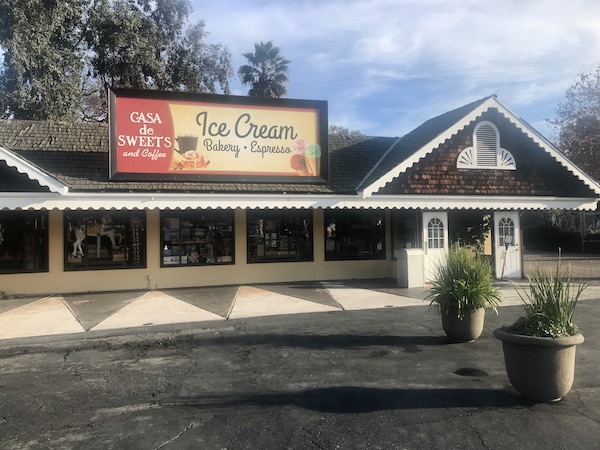A ranch style building with a large red and yellow sign letting you know you're at Casa de Sweets at Casa de Fruta Hollister California