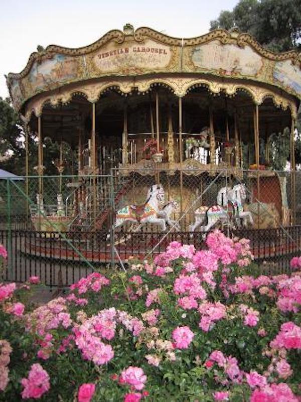 An elaborate carousel with pink flowers in front of it at Casa de Fruta Hollister California