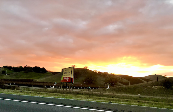 A gorgeous purple, pink and yellow sunset with mountains found while Exploring Hollister California and Beyond