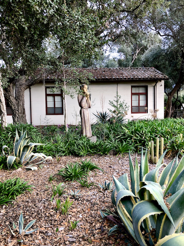 A white house with brown roof and dessert garden in front found while Exploring Hollister California and Beyond