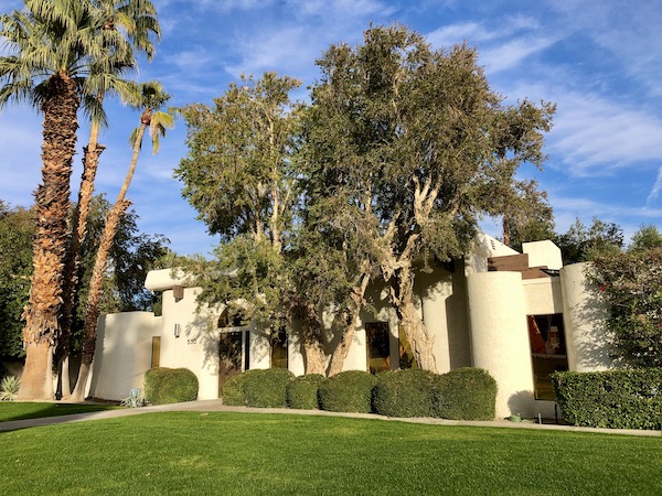A huge white house with lots of trees and green lawn neat Great Shakes in Palm Springs California