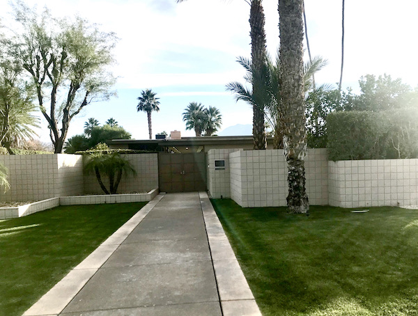 A white privacy wall and the roof of a home near Great Shakes in Palm Springs California