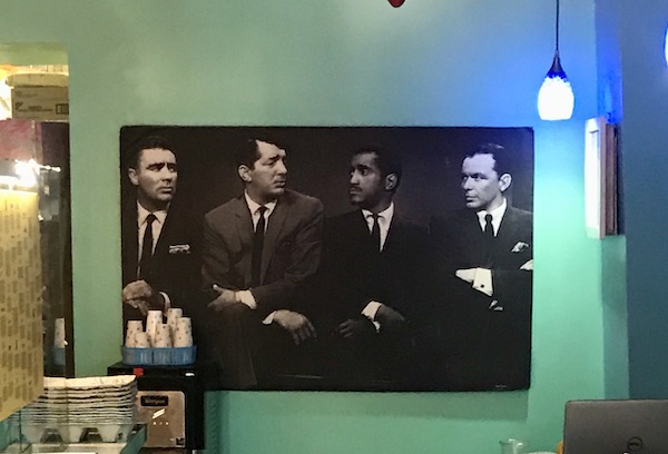 A black and white picture of 4 men in black suits, arms folded in Great Shakes in Palm Springs California
