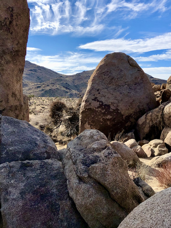 Large boulders and mountains with blue sky at Joshua Tree National Park