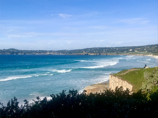 Teal blue ocean with white breaking waves, mountains and beach near the Scenic 17-mile Drive Monterey California