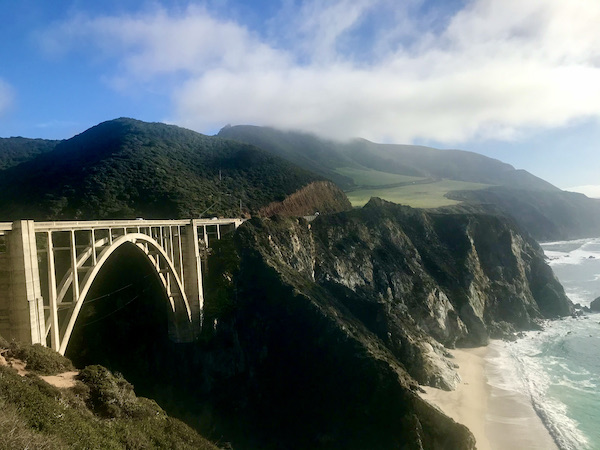 A yellow bridge spans mountains along coast near the Scenic 17-mile Drive Monterey California