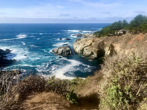 A rocky coastline with cliffs and swirling deep blue ocean water near the Scenic 17-mile Drive Monterey California