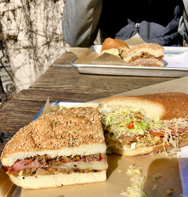 Two brown paper lined sheet trays topped with sandwiches sitting on a picnic table gave us A Taste of New Orleans in Healdsburg CA