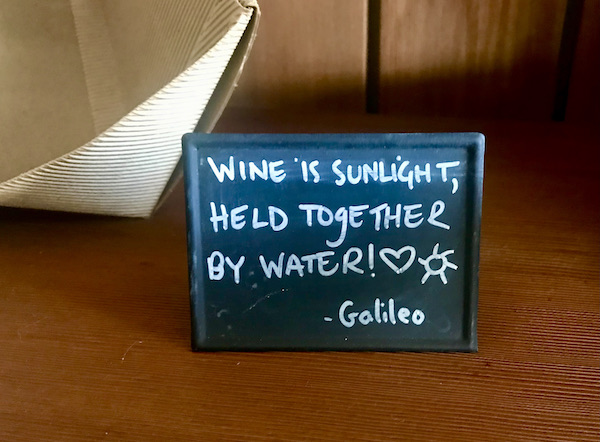 A small black board on a table with a saying by Galileo about wine seen during our Behind the Scenes at Stuhlmuller Vineyards