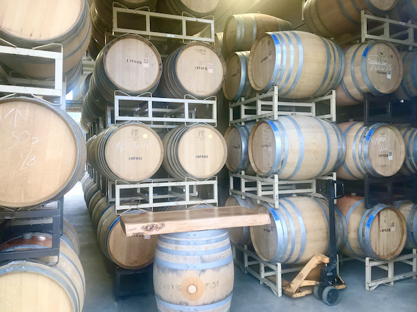 Stacks of wood barrels in a winery seen on our Behind the Scenes at Stuhlmuller Vineyards