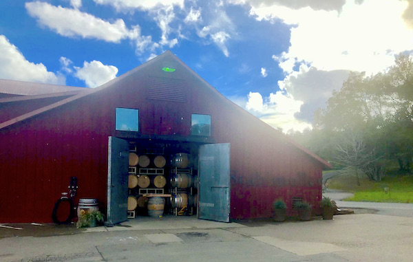 A red barn like building filled with wine barrels Behind the Scenes at Stuhlmuller Vineyards