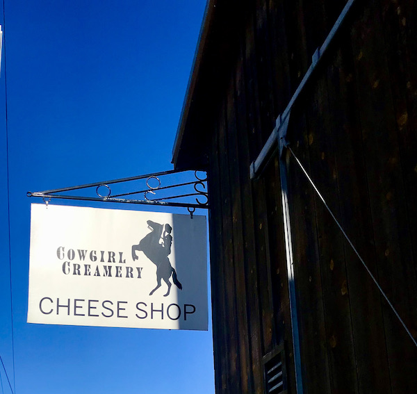 Deep blue sky, a building with a white sign for Cowgirl Creamery that we went to after the Historic Point Reyes Lighthouse