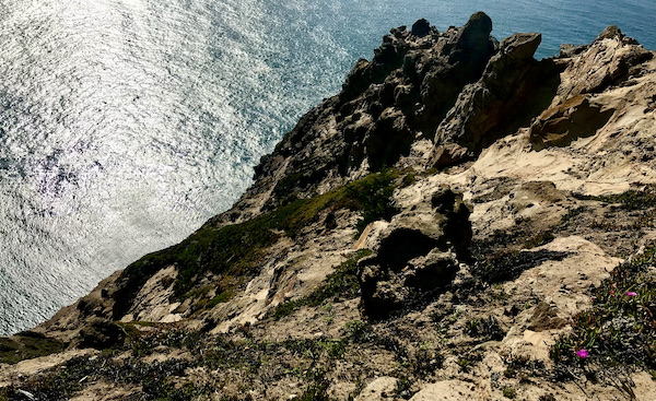 A view of the ocean looking down from a high cliff near the Historic Point Reyes Lighthouse