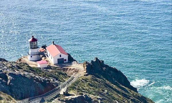 A group of white buildings with red roofs and the Historic Point Reyes Lighthouse