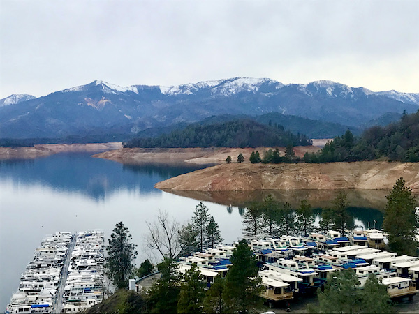 A large mountain lake with houseboats in the water at Mt. Shasta and Shasta Lake California