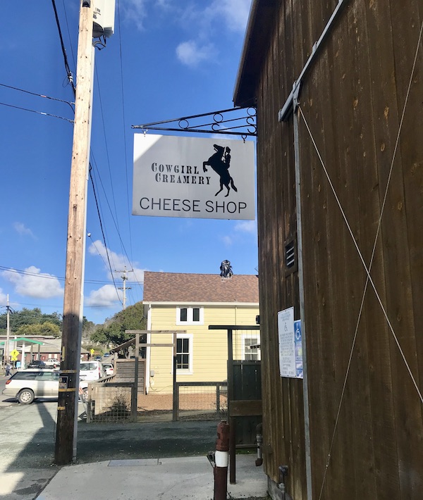 Buildings along the road, one with a white sign Cowgirl Creamery visited on our drive Petaluma to Point Reyes California