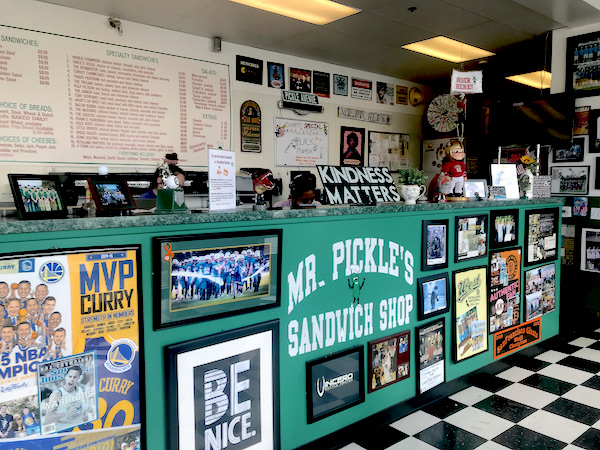 The interior of a sandwich shop with black and white checkered floor and green counter Petaluma to Point Reyes California