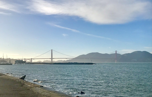 Water, a bridge and a mountain with blue sky and white clouds in San Francisco California