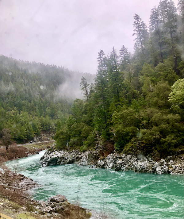 And emerald green river running between rocks and trees on the the mountains on our way to San Francisco California