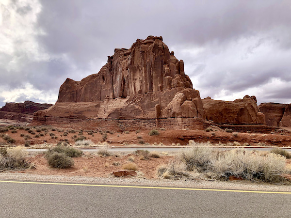 Storm clouds behind a red rock mountain at Arches National Park Moab Utah