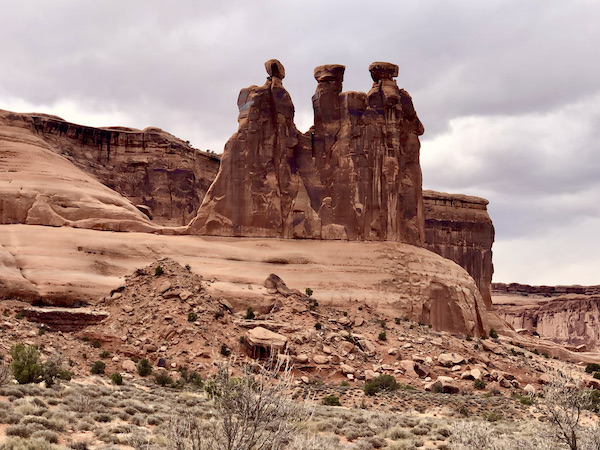 Red rock formations that look like 3 women standing together at Arches National Park Moab Utah