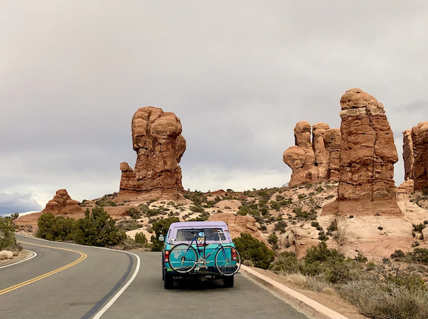 A blue car on the road going passed rocks that look like hands coming out of the ground at Our little guy, Hershi got a haircut today and feels much better about himself. Visit us at https://TheTravelingLocavores.com to follow all our adventures #rvlife #rvtravel #fulltimerv #lifeontheroad #rving #rvliving #Locavores #WeLoveFood #Foodies #TheTravelingLocavores #Wanderlust #Traveling #FoodTravel #TravelFoodBlog #TravelFoodie #FoodStories #TravelPhotography #yorkie #yorkielove