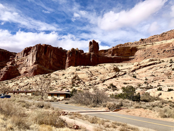 Mountains the look like a castle with sandy landscape in front and blue sky with wispy white clouds at Arches National Park Moab Utah
