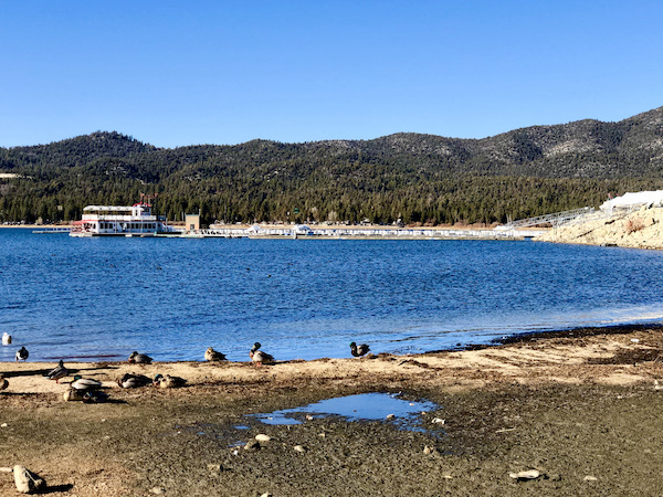 A deep blue lake surrounded by sand and mountains at Big Bear Lake California