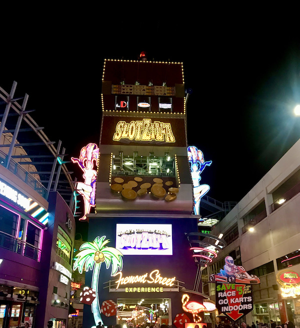 An enormous slot machine in neon the sends passengers on a zipline at Fremont Street Experience Las Vegas NV