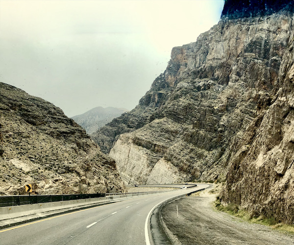 Multiple craggy mountains and curved highway along our Scenic Drive to Moab Utah