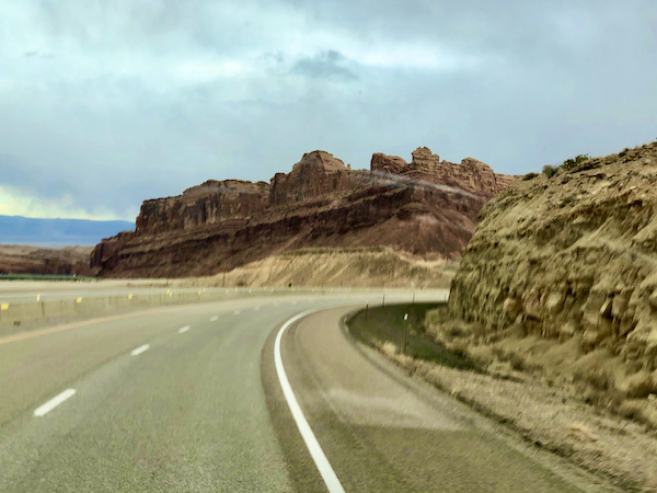 Red rock mountains with highway curving through it on our Scenic Drive to Moab Utah