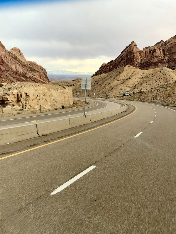 A steep curve on a highway though mountains on our Scenic Drive to Moab Utah