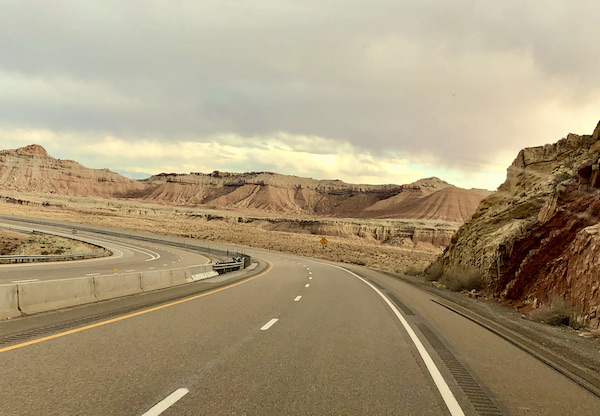 The curve of a highway is highlighted with mountain vistas on our Scenic Drive to Moab Utah