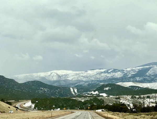 Trees and mountains with snow along our Scenic Drive to Moab Utah