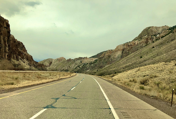Cloudy sky above a highway through mountains on our Scenic Drive to Moab Utah