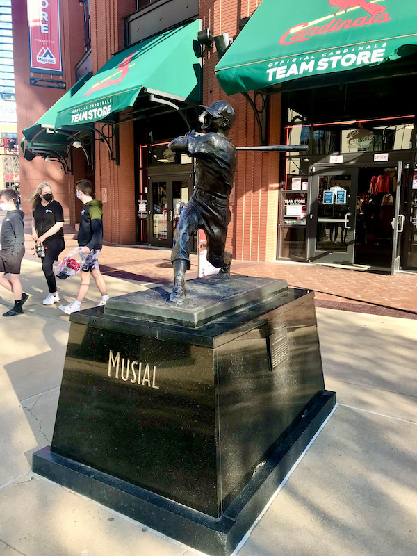 A bronze sculpture of a baseball player swinging a bat in Downtown St. Louis Missouri