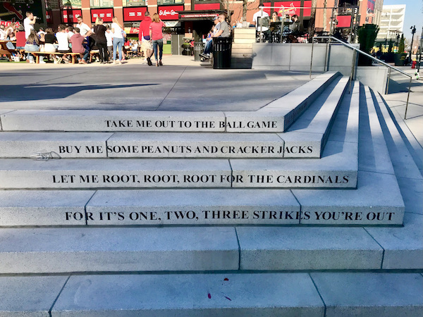 Shallow marble steps. The riser on each step is engraved with words from the sone Take me out to the Ballgame in Downtown St. Louis Missouri