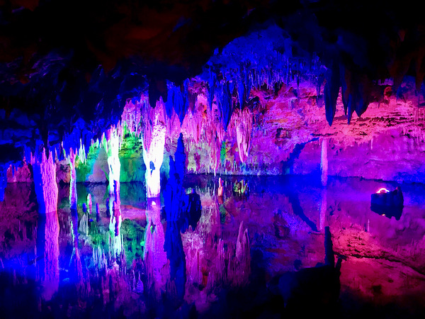 Purple, green and deep pink lights create art inside Meramec Caverns Stanton Missouri