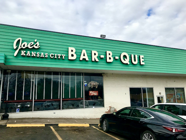The front of a restaurant with a long green roofline.