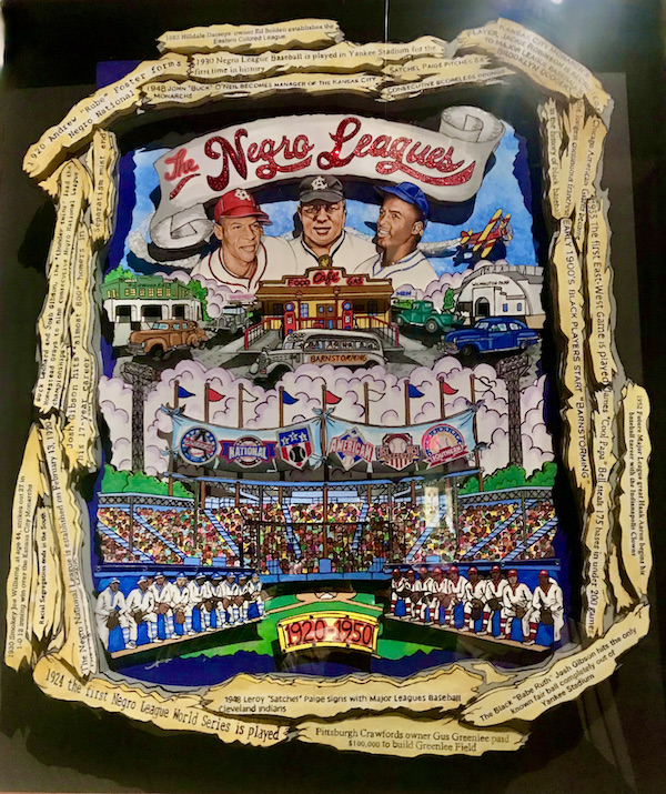 A stylized and colorful wall hanging of baseball players and teams at the Negro Leagues Baseball Museum