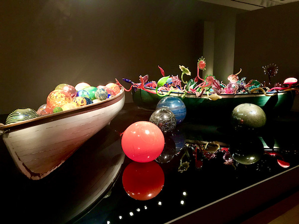 A pair of row boats containing multicolored blown glass which are part of the OKC Museum of Art Dale Chihuly Exhibit