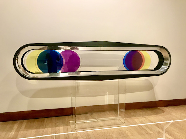A horizontal oval glass sculpture with colored disks inside at the Oklahoma City Museum of Art