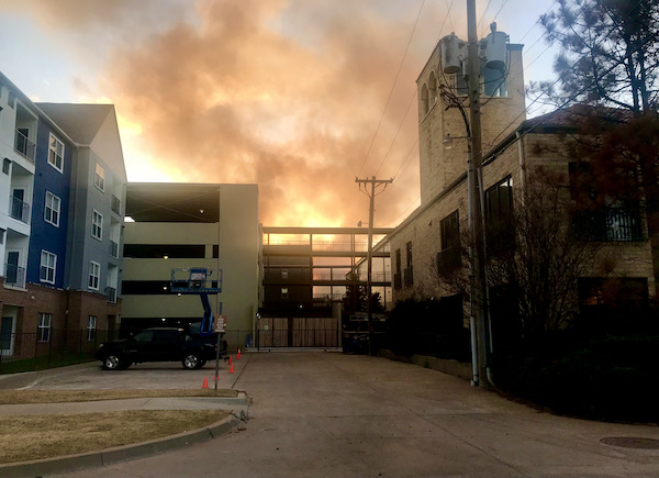 Flames are visible behind buildings on our way to