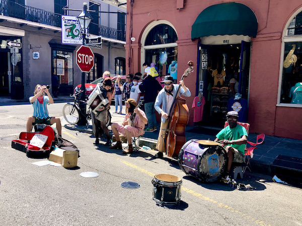 A group of musicians playing in front of a red brick building.