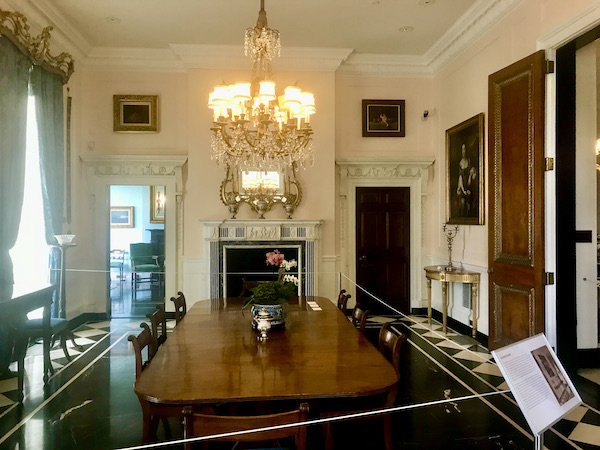A large room with big wood table and chairs and glass and brass chandelier in the dining room at Cheekwood Estate Nashville TN
